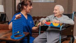 Care Assistant and Resident enjoying a game of connect 4 and a laugh at Riseley House Care Home in Macclesfield